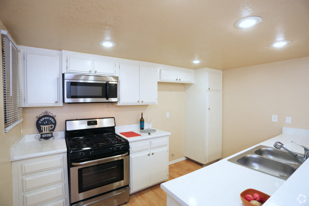 a kitchen with stainless steel appliances and white cabinets